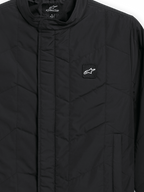 Alpinestars Precedent jas, gestept sportswear jack, zwart, detailopname met een iconisch schuin gestikt patroon, lage kraag, bedekte rits aan de voorzijde en kleine logopatch op de borst