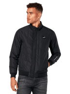 Alpinestars Precedent jas, zwarte gewatteerde jas met schuin patroon, Formule 1-stijl, lage kraag, geribbelde manchetten en zoom, logopatch op de borst, borduursel op de mouw, lifestyle streetwear geïnspireerd op de motorsport