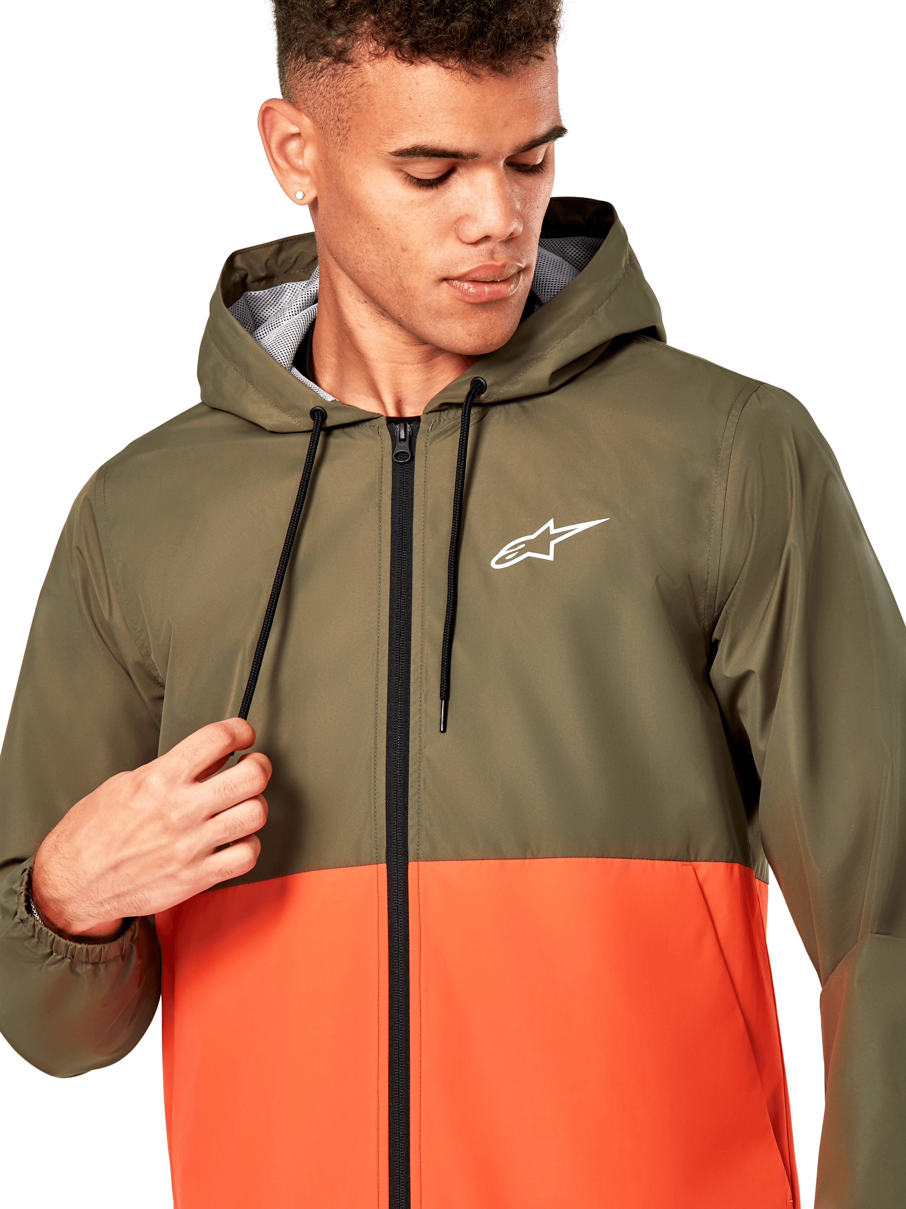 Alpinestars Speeder Windbreaker Jacket, coupe-vent léger à capuche, design color-block vert olive et orange militaire, logo Alpinestars blanc sur la poitrine, fermeture éclair et cordons de serrage noirs, vêtement de sport décontracté inspiré des sports mécaniques