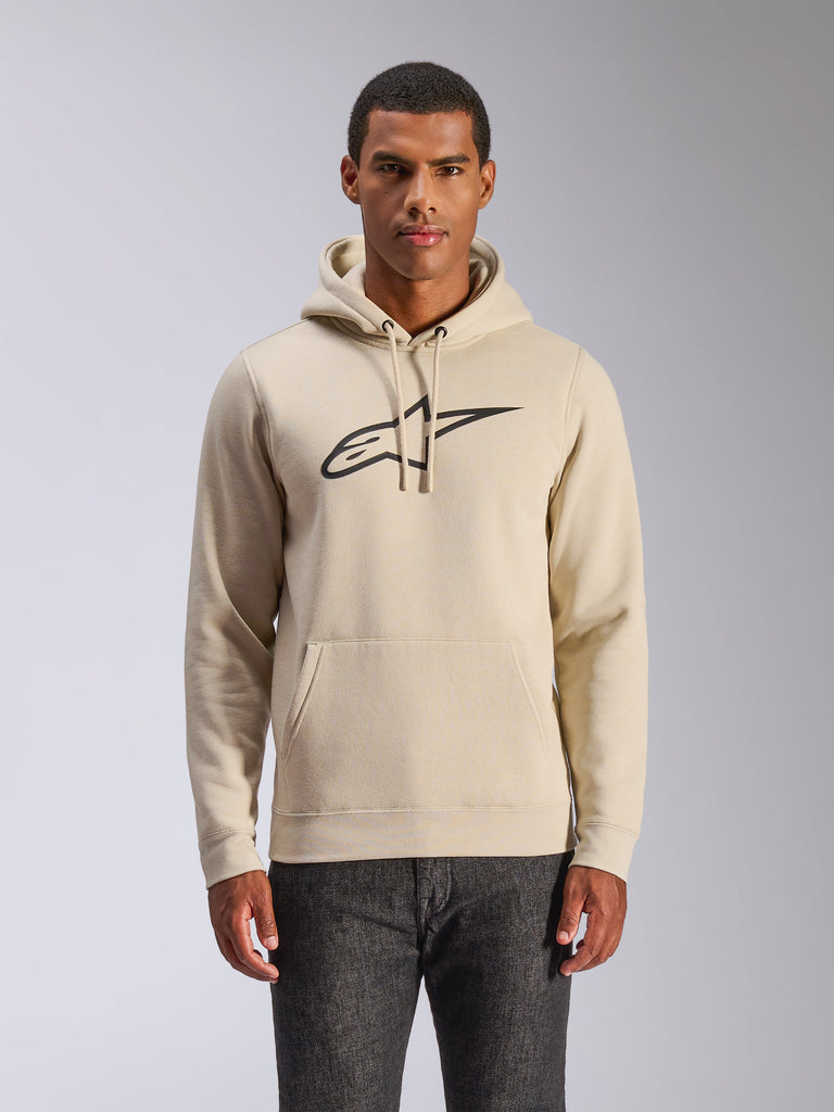Sweat à capuche Alpinestars Ageless V3, streetwear décontracté, blanc cassé avec logo brodé noir, pull avec capuche à cordon de serrage et poche kangourou, porté par un mannequin avec un pantalon sombre, design moderne inspiré des sports mécaniques