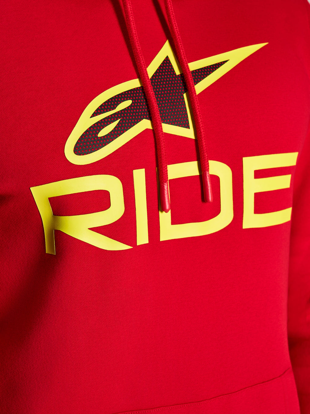 Alpinestars Ride V3 Hoodie, close-up van de grafische print op de borst, rood met Hi-Vis gele RIDE-tekst en zwart geperforeerd sterlogo, rode trekkoorden met gedipte uiteinden, premium fleece casual streetwear