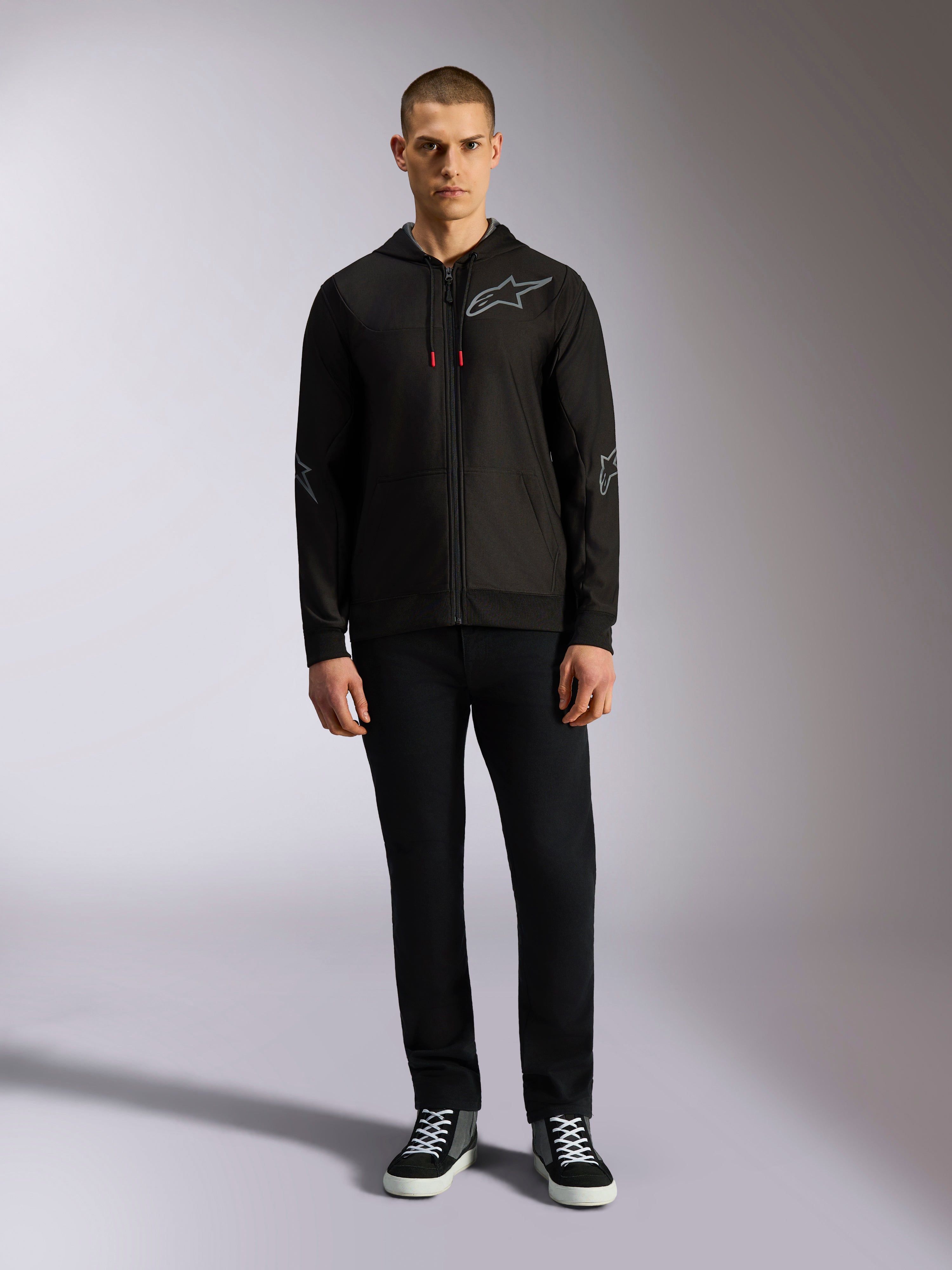 Alpinestars Sessions V3 Hoodie, fleece hoodie met ritssluiting aan de voorzijde, zwart met grijs Astars-logo op de borst en mouwen, trekkoorden met rode uiteinden, casual op motorsport geïnspireerde streetwear.