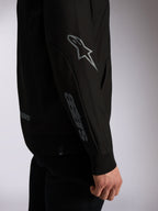Alpinestars Sessions V3 Hoodie, zwarte casual streetwear, close-up van mouw met grijs Astars-logo op elleboog en woordmerk op onderarm, geribde manchetten, motorsport-geïnspireerd ontwerp