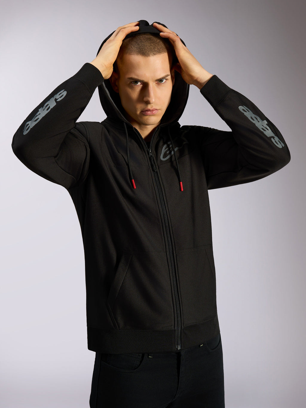 Alpinestars Sessions V3 Hoodie, zwarte hoodie met volledige ritssluiting, grijze Astars-branding op de onderarmen, capuchon met mesh-voering en trekkoorden met rode uiteinden, casual motorsport-geïnspireerde streetwear