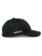 Alpinestars Sessionized pet, zijaanzicht van zwarte snapback cap, goudkleurig plat Astars borduurwerk aan de zijkant, gestructureerde kroon met gebogen klep, casual motorsport-geïnspireerde hoofdbedekking