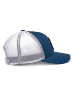 Casquette Trucker Alpinestars Gambit, bleu et blanc, vue de profil, visière courbée avec couronne structurée, panneaux avant en sergé bleu et dos en maille polyester blanche, couvre-chef décontracté inspiré des sports mécaniques