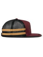 Alpinestars Backline Trucker Mütze, Brick, Schwarz und Senfgelb, Seitenansicht, dunkelrote Twill-Vorderseite mit schwarzem Mesh-Rücken und gelben Seitenstreifen, flacher Schirm mit schwarzem Soutache-Besatz, lässige vom Motorsport inspirierte Kopfbedeckung