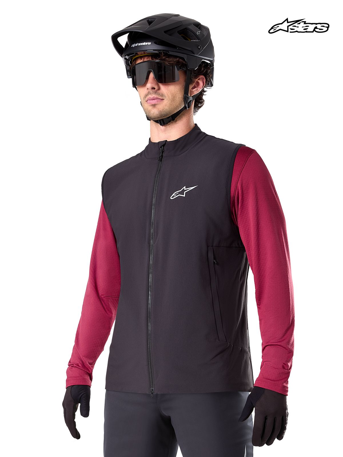 Alpinestars A-Dura Thermal Vest, men's mountain biking thermal vest in black, worn by a model with a helmet and a red long-sleeve jersey, insulation for cold-weather MTB riding