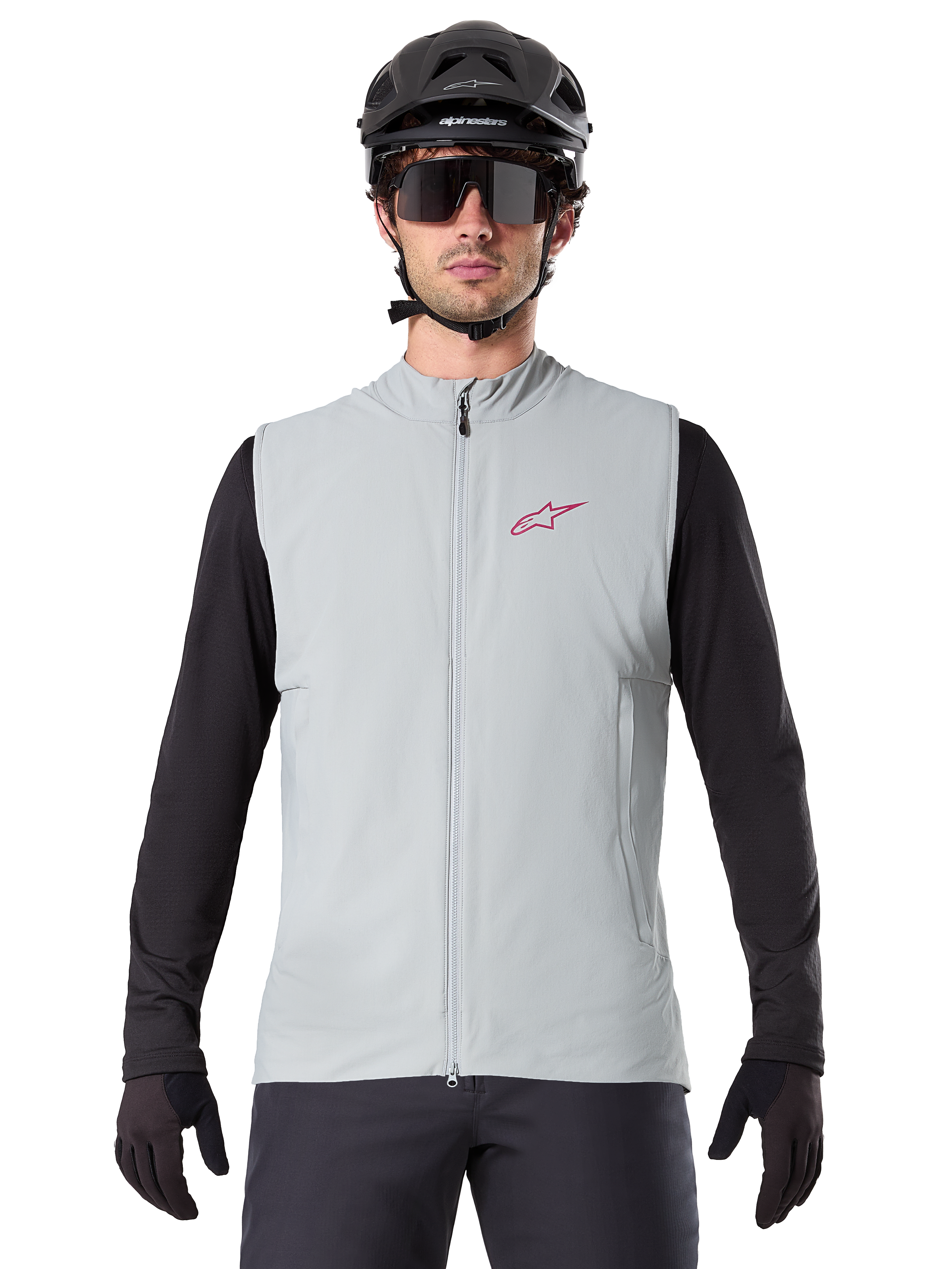 Gilet thermique Alpinestars A-Dura, gilet de cyclisme, gris Titanium, porté avec un maillot noir à manches longues et un casque de cyclisme noir, logo étoile Alpinestars rouge sur la poitrine, léger et isolé pour le VTT
