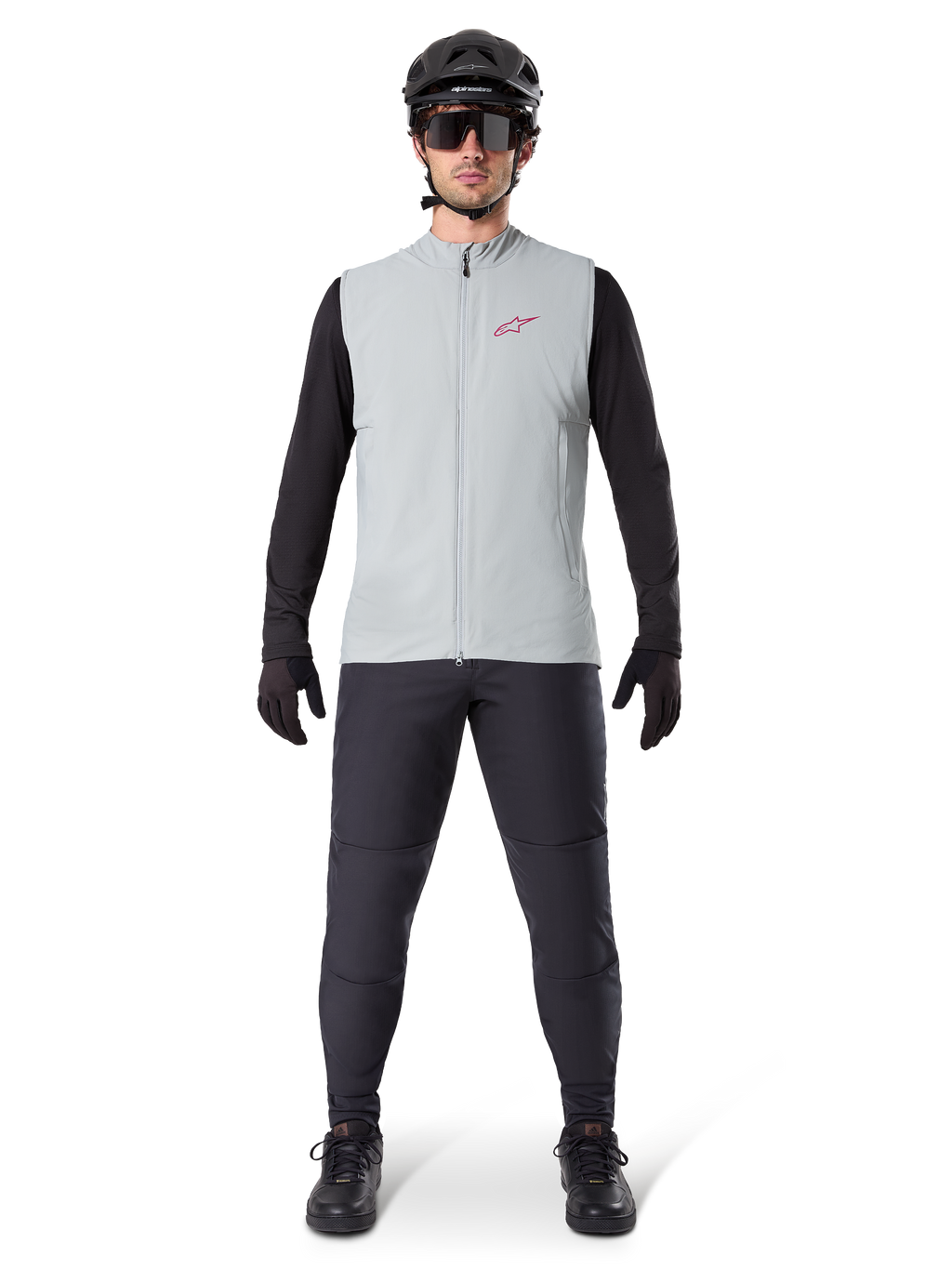 Gilet thermique Alpinestars A-Dura, gilet de cyclisme, gris titane, porté avec un maillot à manches longues noir et un pantalon noir, casque noir et lunettes de soleil, avec un logo Alpinestars rouge, isolation thermique légère pour le VTT