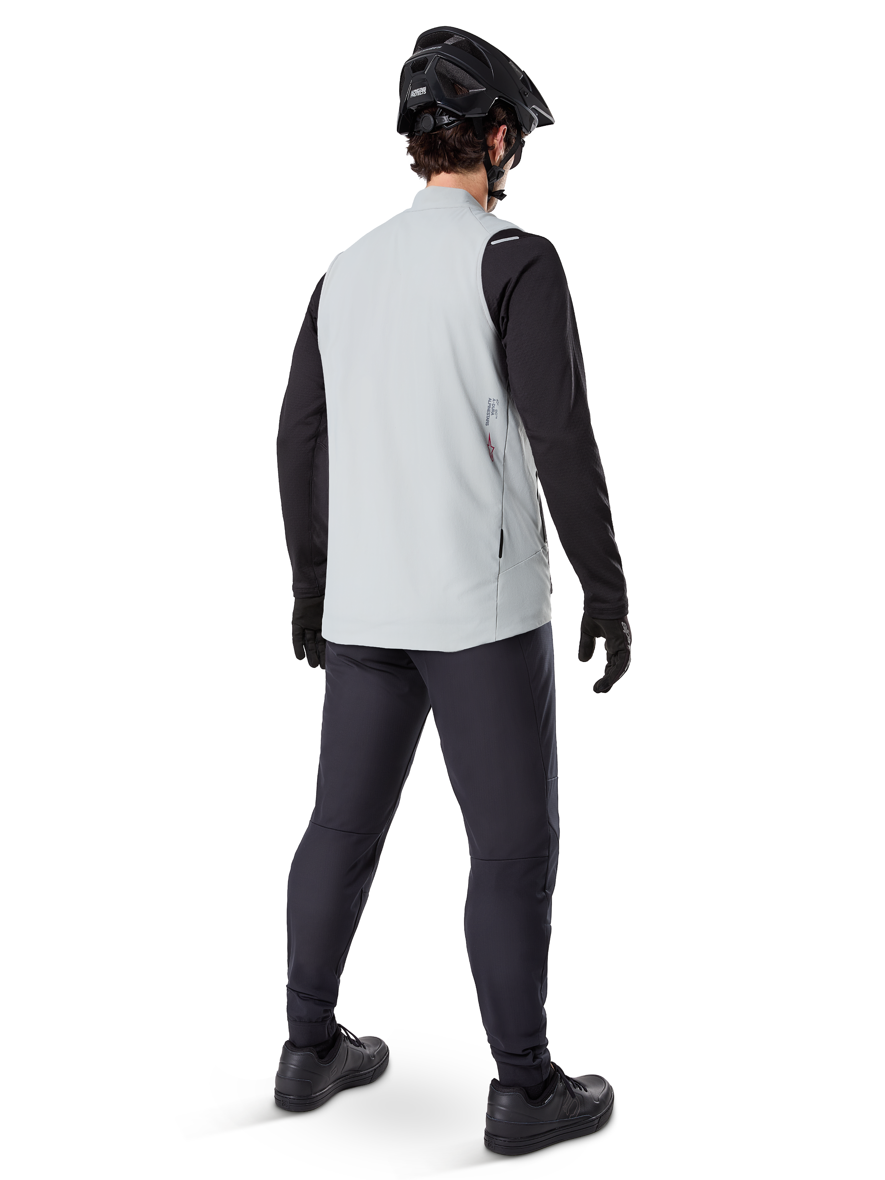 Alpinestars A-Dura Thermal Vest, Gris Titanium, vue arrière d'un mannequin portant le gilet de cyclisme isolant sur un haut noir à manches longues et un pantalon sombre, avec un casque de VTT noir et des gants, conçu pour la conduite tout-terrain par temps froid
