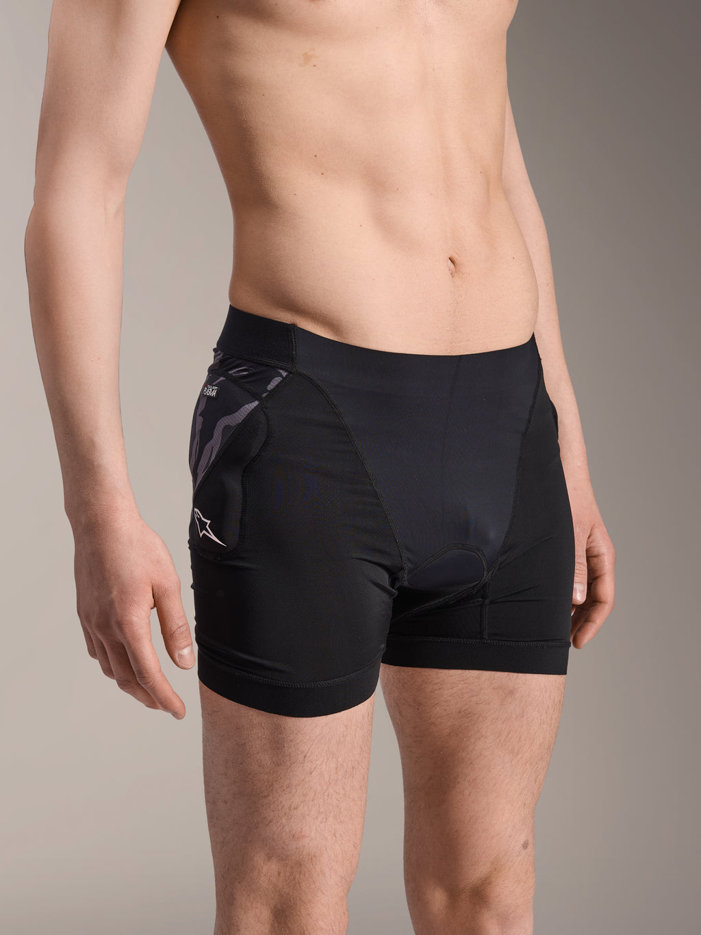 Boxers de protection Alpinestars A-Motion Plasma, sous-short de cyclisme noir, doté d'une protection de hanche à motif camouflage avec logo Astar blanc, tissu en maille respirante, équipement de protection pour le VTT
