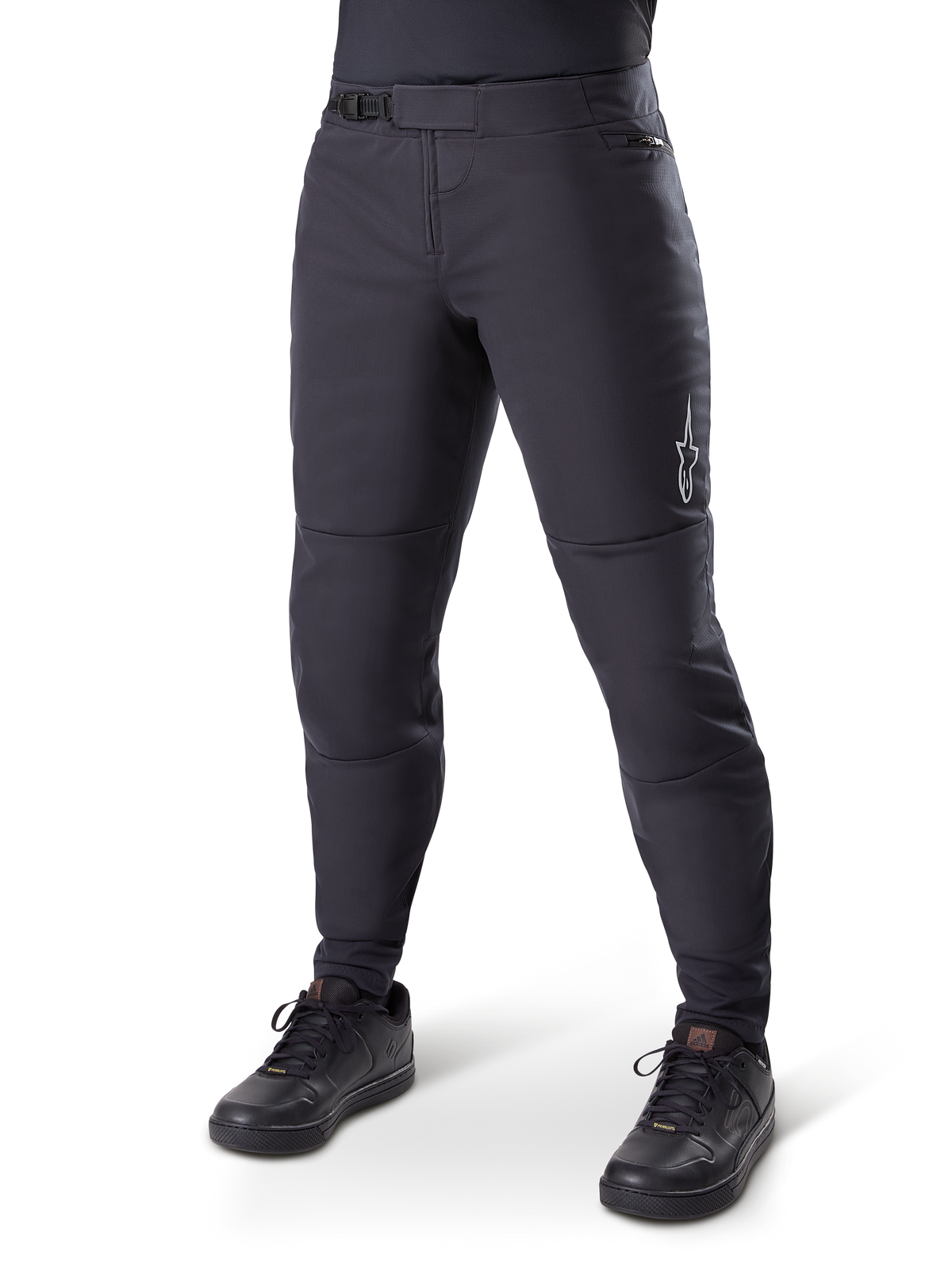 Alpinestars A-Dura Thermal Pant, pantalon de VTT noir, porté avec des chaussures de cyclisme noires, doté d'une fermeture à cliquet à la taille, petit logo blanc sur la cuisse, coupe ajustée pour le cyclisme par temps froid