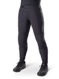 Alpinestars A-Dura Thermal Pant, pantalon de VTT noir, porté avec des chaussures de cyclisme noires, doté d'une fermeture à cliquet à la taille, petit logo blanc sur la cuisse, coupe ajustée pour le cyclisme par temps froid