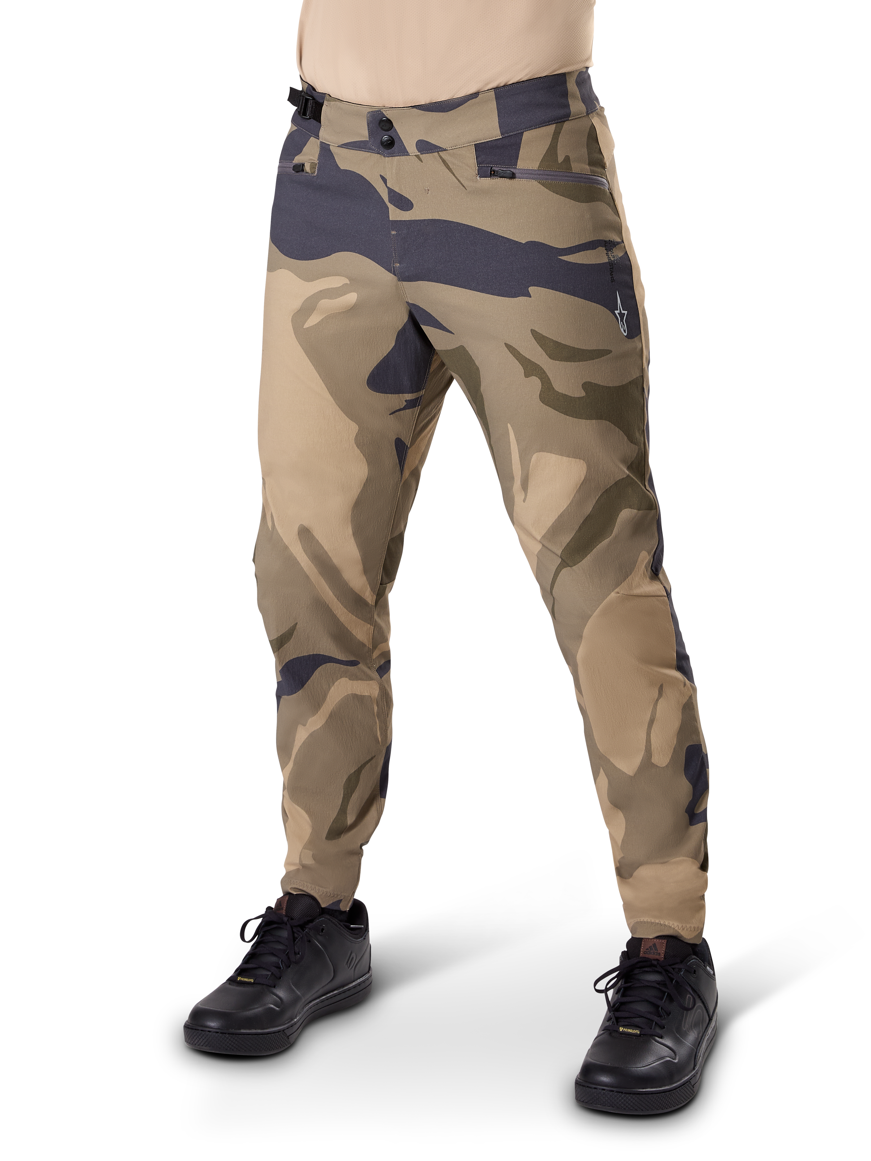 Alpinestars A-Dura Camo Pant, pantalon de cyclisme VTT, camouflage brun, doté d'une double fermeture à pression et de poches zippées, coupe régulière pour le VTT tout-terrain, porté avec des chaussures noires