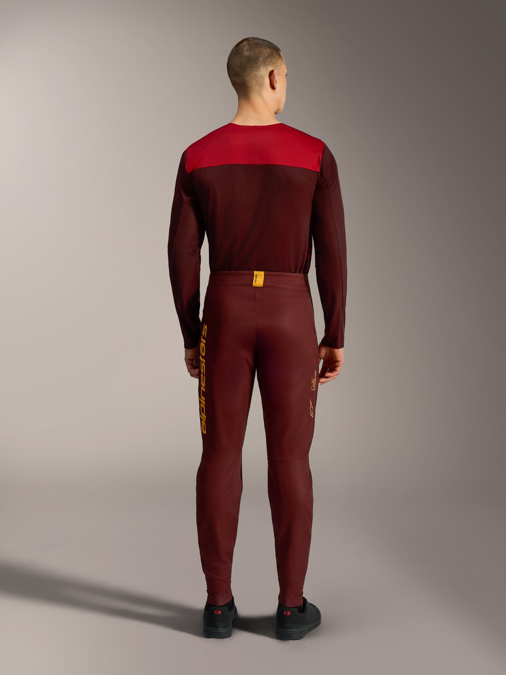 Bordeaux A-Dura Elite Flex Broek, achteraanzicht met gele Alpinestars-logo's en flexibele stretchstof voor mountainbiken.