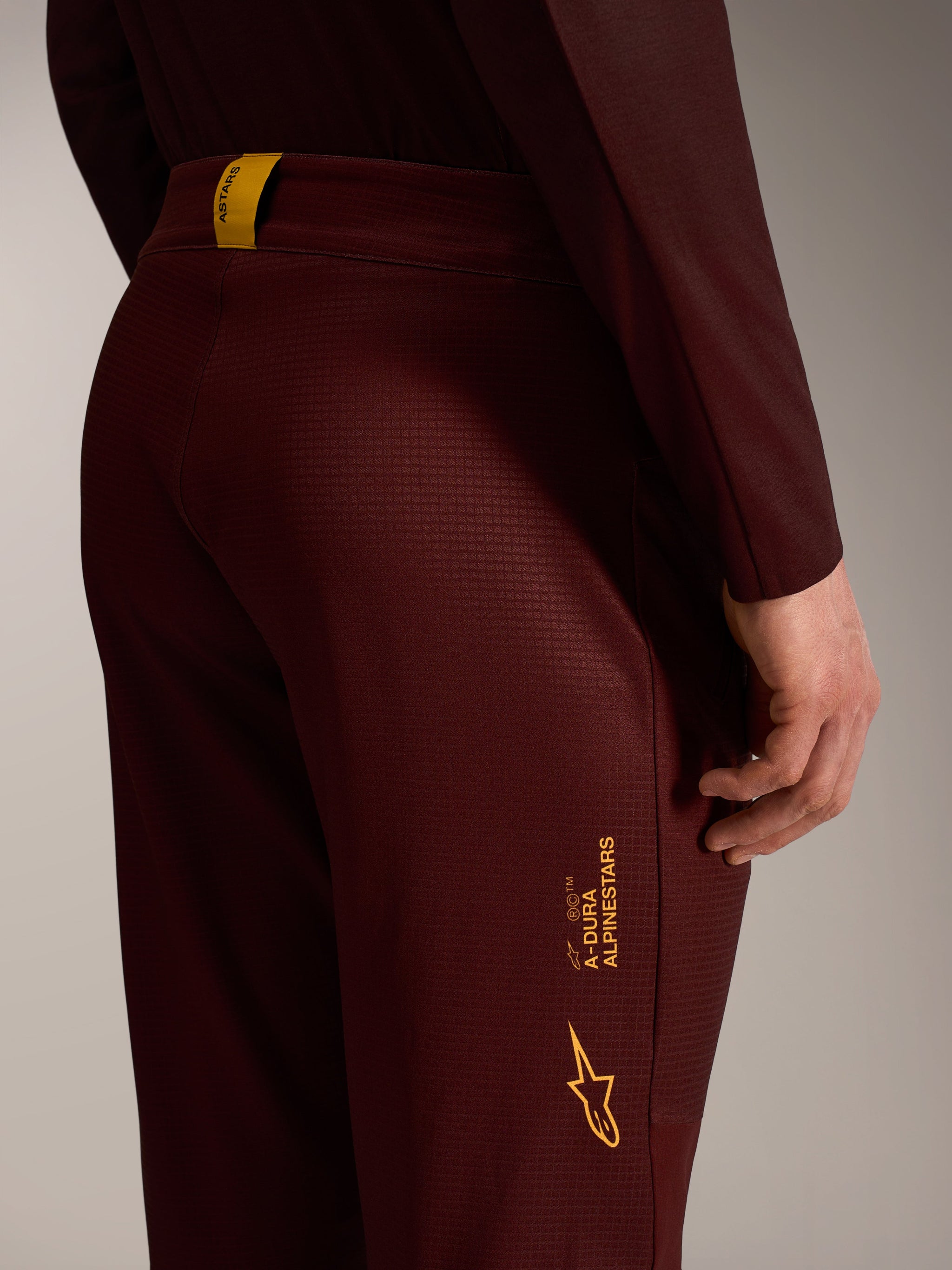 A-Dura Elite Flex Broek in bordeaux, van duurzaam ripstop met gele Alpinestars branding op de achterdij.