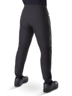 Pantalon imperméable Alpinestars A-Dura, pantalon de VTT, noir, vue arrière porté avec des chaussures noires, doté d'une membrane durable à 3 couches, coupe régulière et poignets élastiqués pour le cyclisme tout-terrain