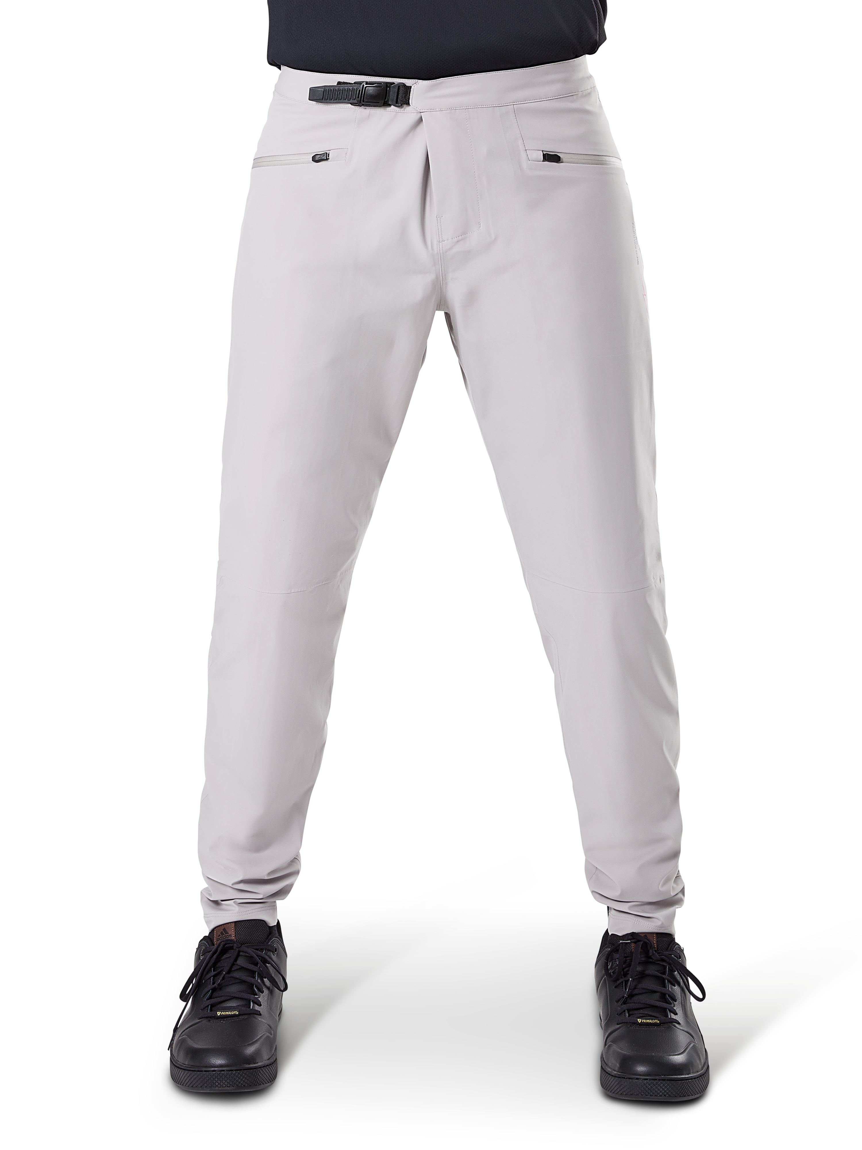 Pantalon imperméable Alpinestars A-Dura, pantalon de cyclisme VTT, Gris Titane, vue de face, avec fermeture à cliquet noire à la taille, deux poches zippées et chevilles élastiquées, porté avec des baskets noires, équipement technique imperméable pour le VTT