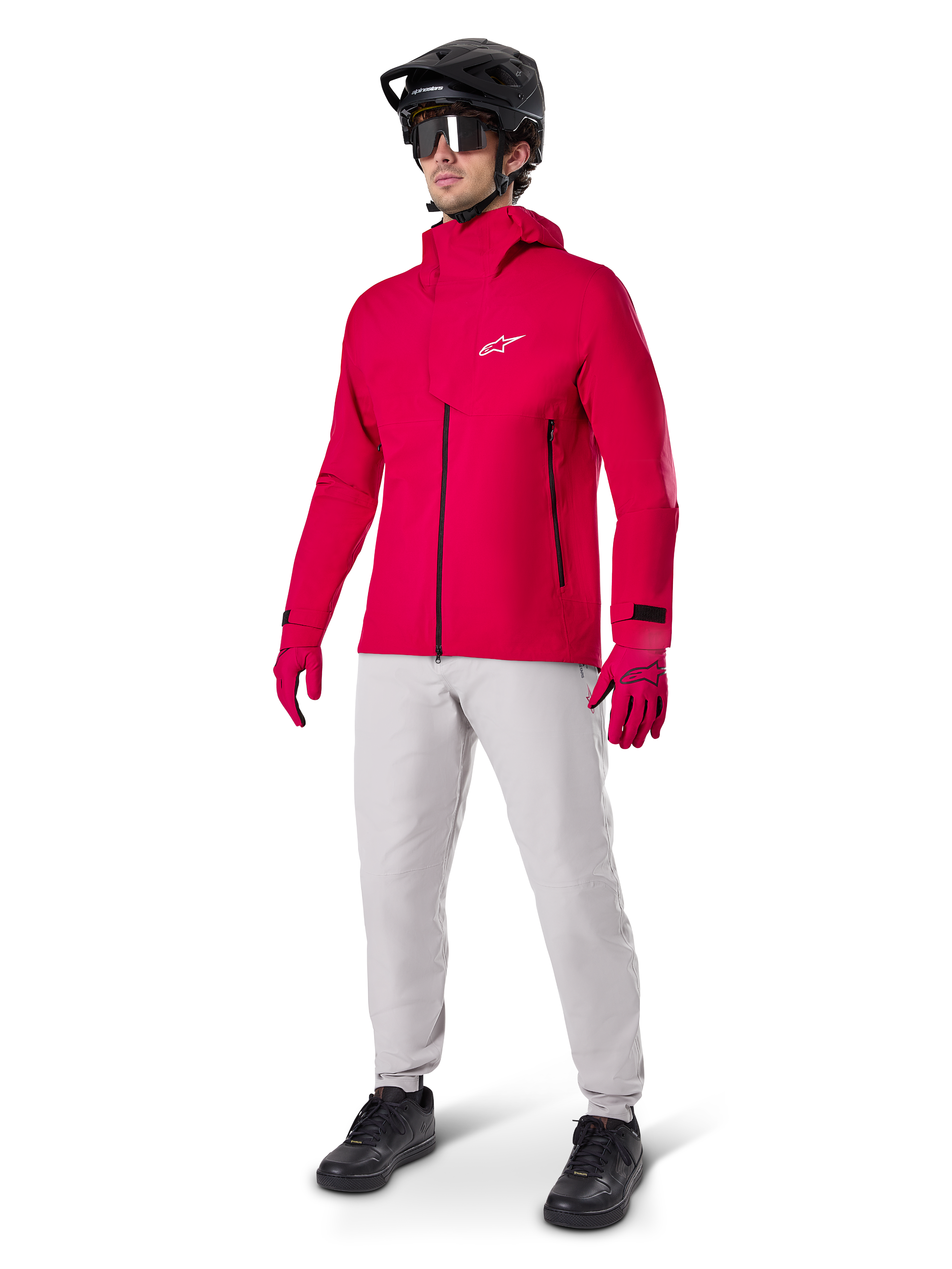 Mannequin portant le pantalon imperméable Alpinestars A-Dura en gris Titanium, associé à une veste imperméable rouge vif, des gants assortis, un casque de VTT noir avec masque et des chaussures noires, équipement complet de VTT pour conditions humides