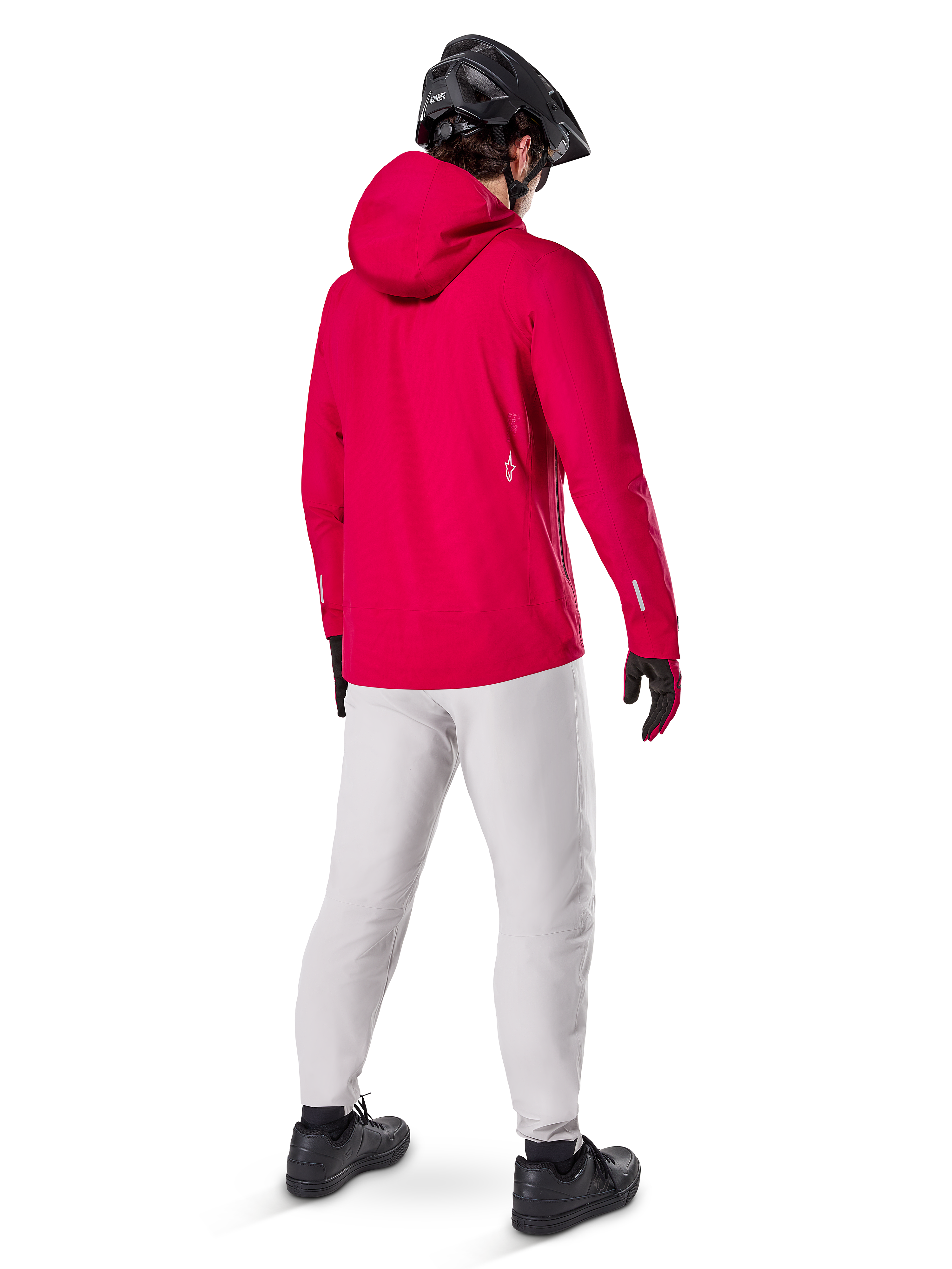 Pantalon imperméable Alpinestars A-Dura Titanium, vue arrière d'un cycliste portant un pantalon technique de VTT gris clair, veste à capuche rouge vif et casque noir, équipement imperméable durable pour le cyclisme par temps humide