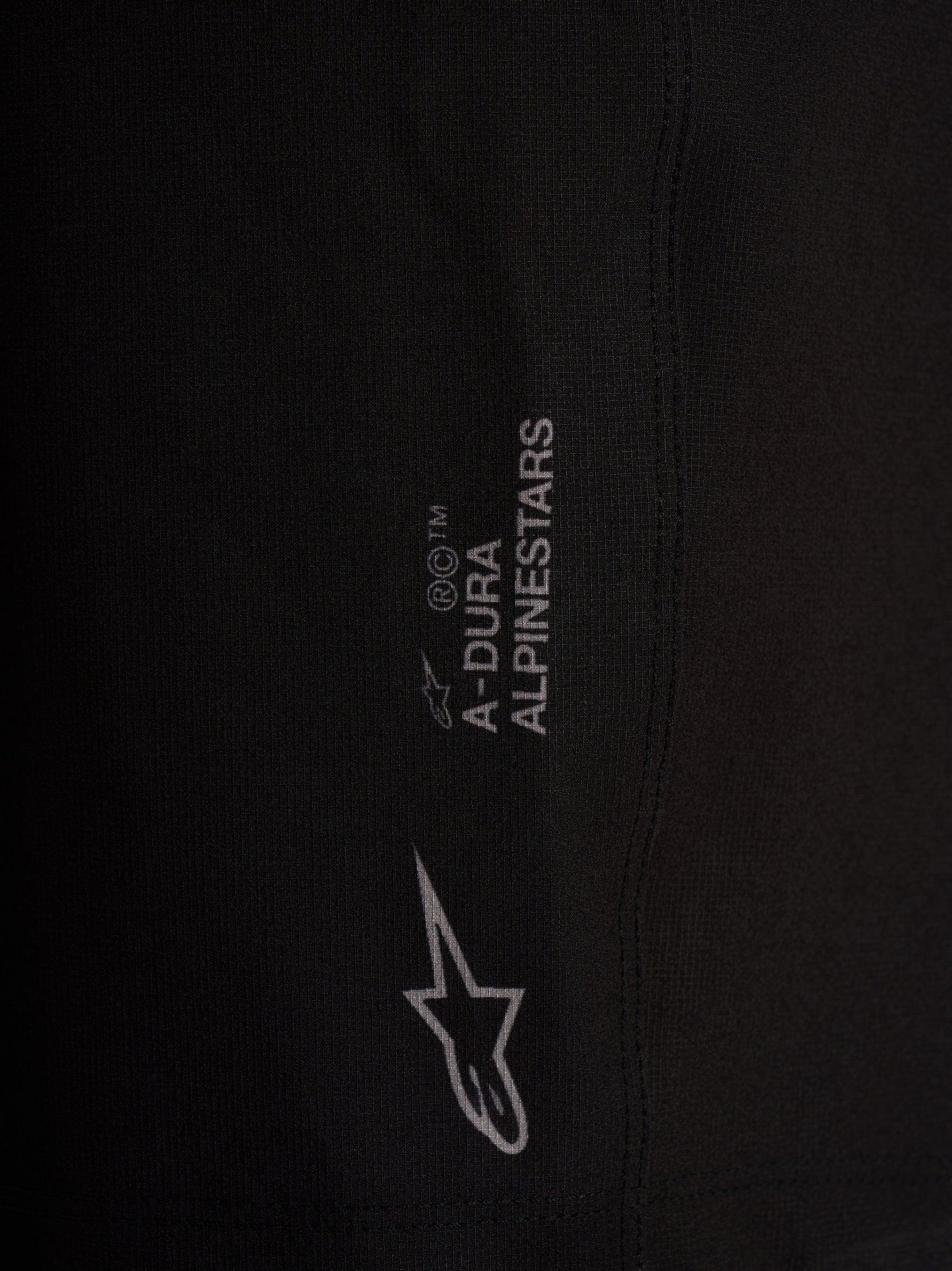Detail of black Alpinestars A-Dura Ride Liner Shorts with white logos on 4-way stretch performance cycling fabric.