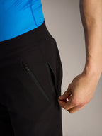 Zwarte Alpinestars A-Dura Ride MTB-shorts, close-up van een hand die een veilige zijzak met rits opent.