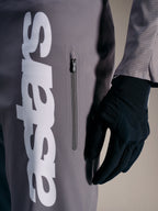 A-Supra Elite broek in Faded Gray met opvallend wit logo en verticale ritszak, ontworpen voor MTB-raceprestaties.