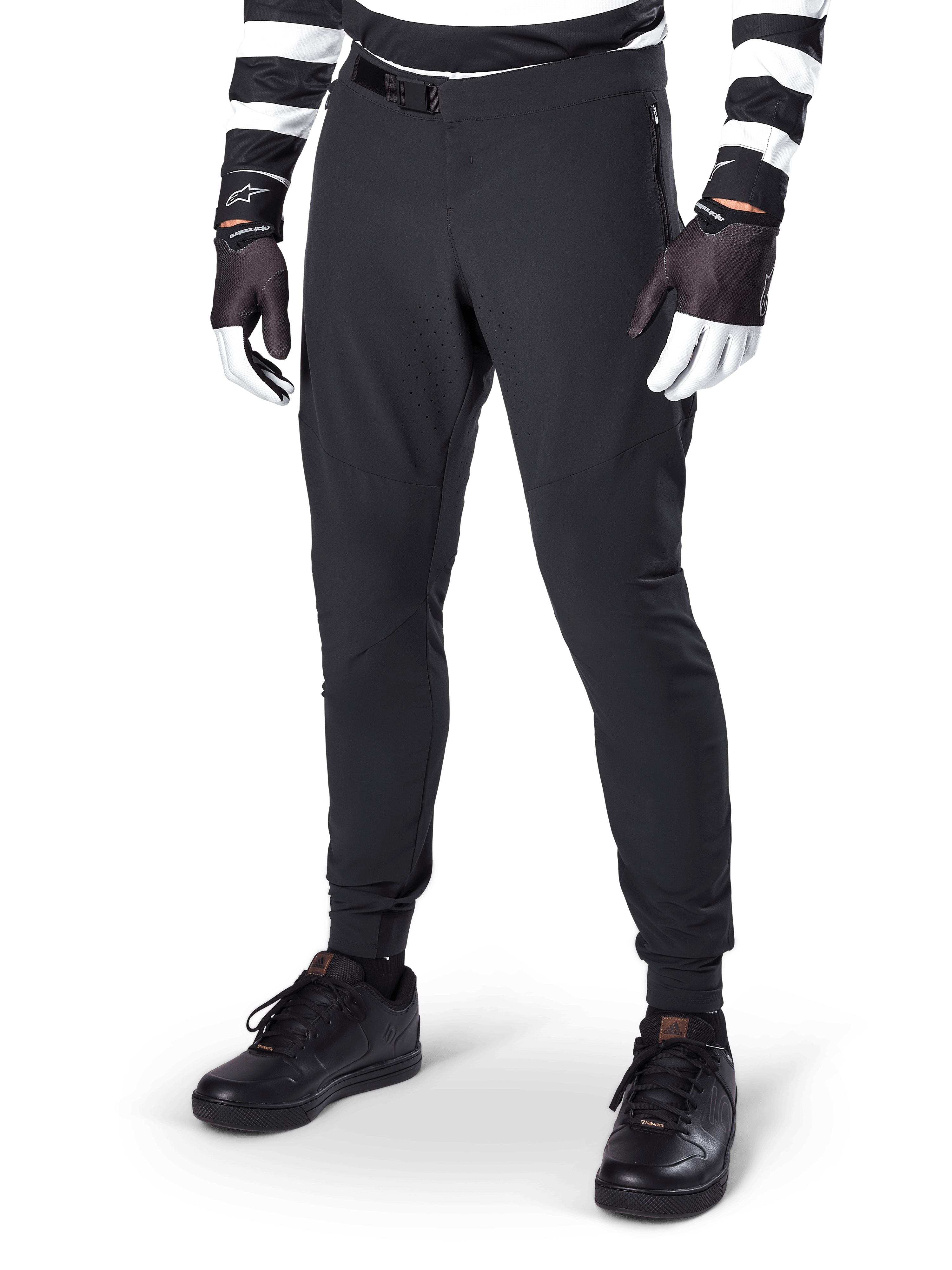 Alpinestars A-Aria Elite Pants, Black Mountain Bike Pants, featuring laser-cut ventilation on thighs and magnetic buckle closure, worn with black and white striped jersey and gloves, performance MTB gear for off-road cycling