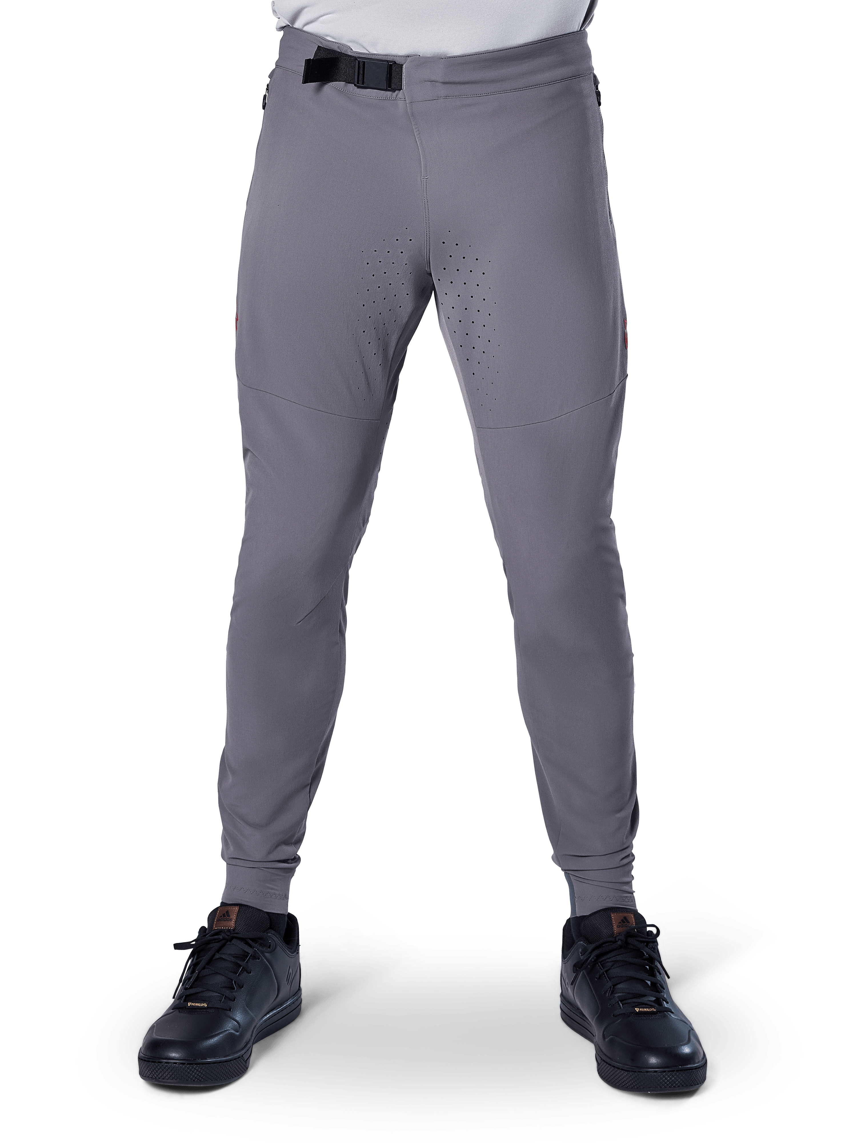 Pantalon Alpinestars A-Aria Elite, pantalon de VTT, gris foncé, doté de perforations laser sur l'intérieur des cuisses pour la ventilation et d'une fermeture par boucle magnétique à la taille, coupe performance avec jambes fuselées, porté avec des chaussures de sport noires