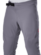 Pantalon Alpinestars A-Aria Elite, pantalon de VTT, gris foncé, vue rapprochée présentant la fermeture à boucle magnétique, la poche latérale zippée et les perforations de ventilation laser sur l'intérieur des cuisses pour la performance en trail.