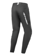 Alpinestars A-Dura Elite Pants, pantalon de VTT, noir, vue latérale arrière avec logo Alpinestars argenté sur la cuisse, poche zippée et poignets élastiqués, équipement technique durable pour le VTT