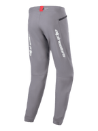 Alpinestars A-Dura Elite Pants, MTB-fietsbroek, donkergrijs, achteraanzicht met witte Alpinestars-branding op de broekspijpen, klein rood label bij de tailleband en zak met ritssluiting, technisch ontwerp voor mountainbiken