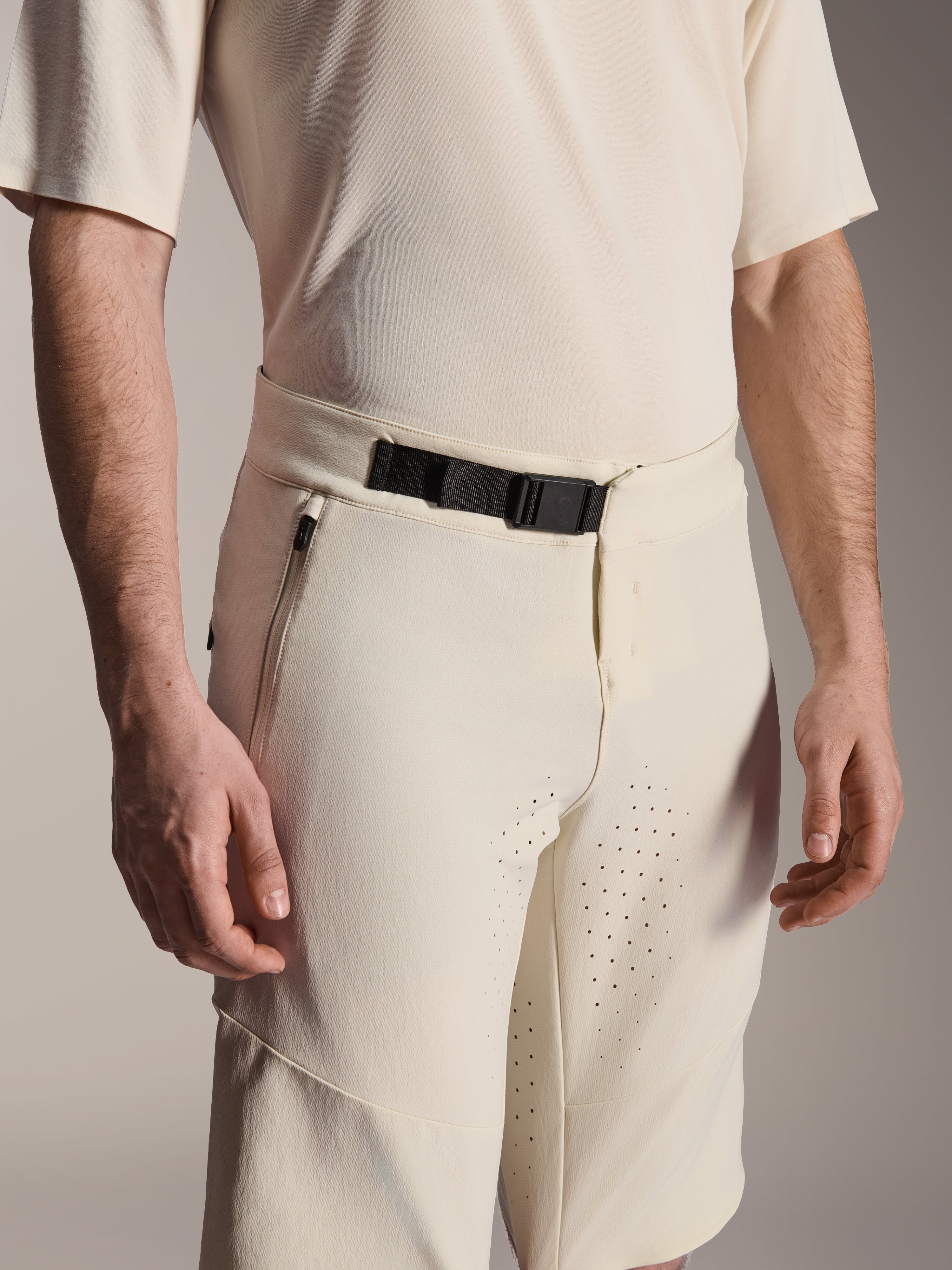 Alpinestars A-Aria Elite Shorts, Mountainbike-Shorts, Ecru, Nahaufnahme mit schwarzem Magnet-Schnallenverschluss, seitlicher Reißverschlusstasche und lasergeschnittener Belüftung, technische Performance-Radsportbekleidung