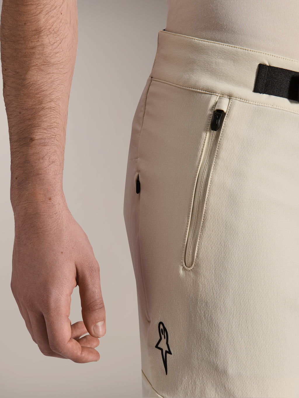 Alpinestars A-Aria Elite Shorts, Mountainbike-Shorts, Ecru, Nahaufnahme der Seitenansicht mit Reißverschlusstasche und Magnetverschluss, Performance-Radbekleidung mit schwarzen Akzenten