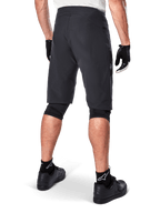 Short Alpinestars A-Aria, short de VTT, noir, vue arrière montrant la coupe performance et le design épuré, porté avec des gants noirs et des chaussettes arborant le logo blanc Astars, équipement de cyclisme technique pour le tout-terrain