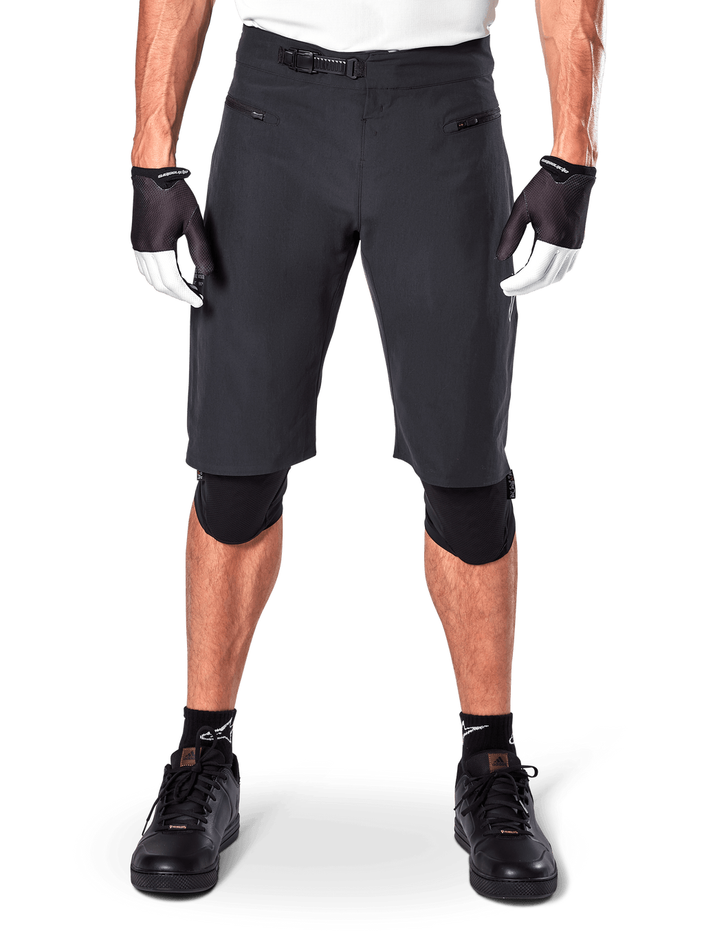 Short Alpinestars A-Aria, short de VTT noir, doté d'une fermeture à rochet à la taille et de poches zippées, porté avec des gants noirs et blancs et des genouillères, équipement technique de cyclisme pour le tout-terrain