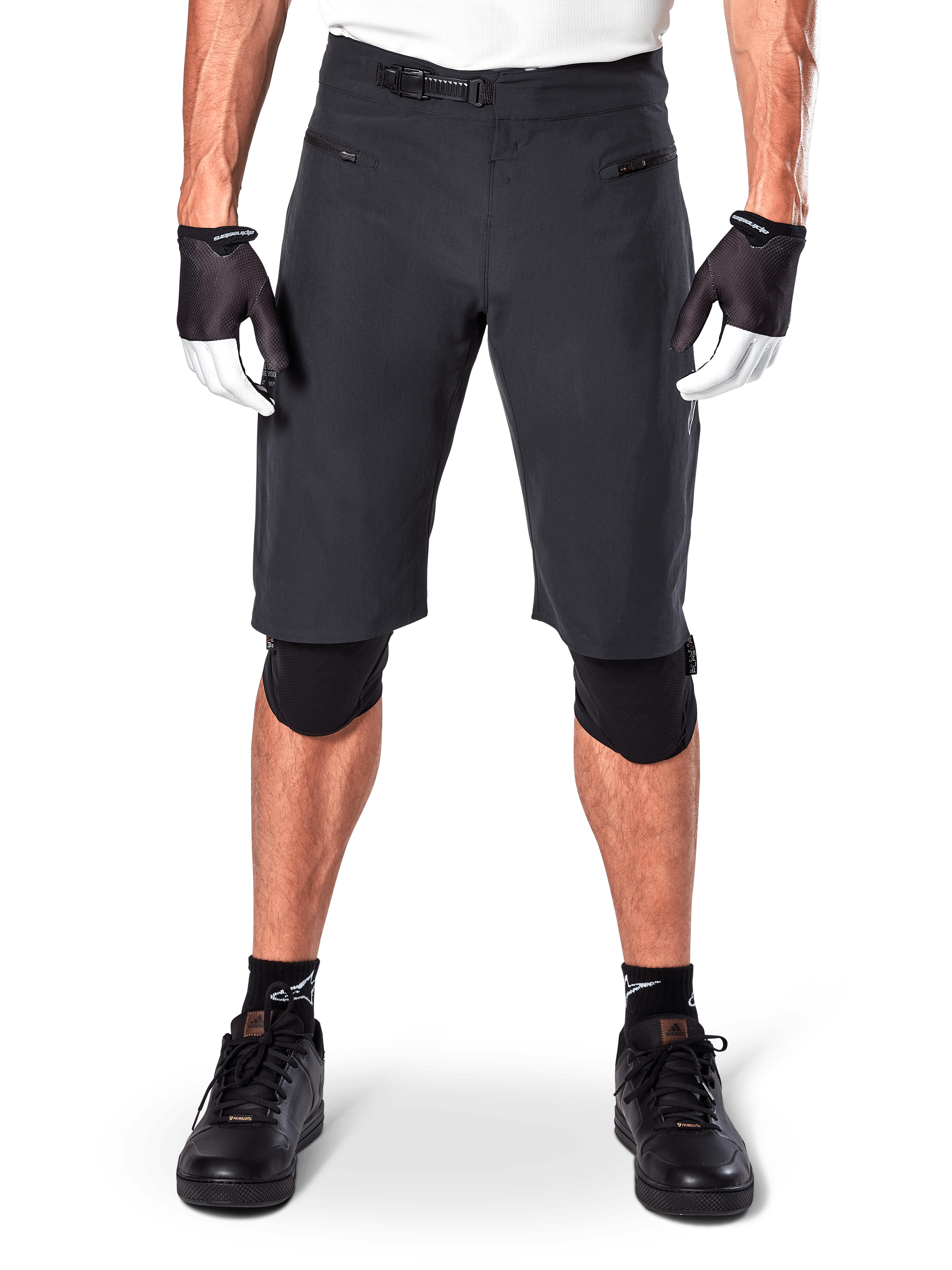 Short Alpinestars A-Aria, short de VTT noir, doté d'une fermeture à rochet à la taille et de poches zippées, porté avec des gants noirs et blancs et des genouillères, équipement technique de cyclisme pour le tout-terrain