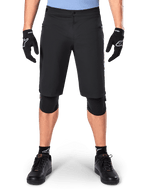Shorts Alpinestars A-Dura Elite, short de VTT noir, porté par un cycliste avec des gants noirs et des genouillères, doté d'une fermeture à bouton-pression à l'avant et de poches zippées, matériau Cordura durable pour le cyclisme tout-terrain