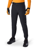 Alpinestars A-Dura Pants, mountainbikebroek, zwart, met zijsluitingen en zakken met rits, gedragen met oranje jersey en handschoenen, sportieve regular fit voor mountainbiken