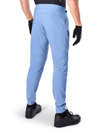 Alpinestars A-Dura Pants, mountainbikebroek, Infinity Blue, achteraanzicht met regular fit en elastische manchetten, gedragen met zwarte handschoenen en zwarte schoenen, duurzame fietskleding met 2-way stretch
