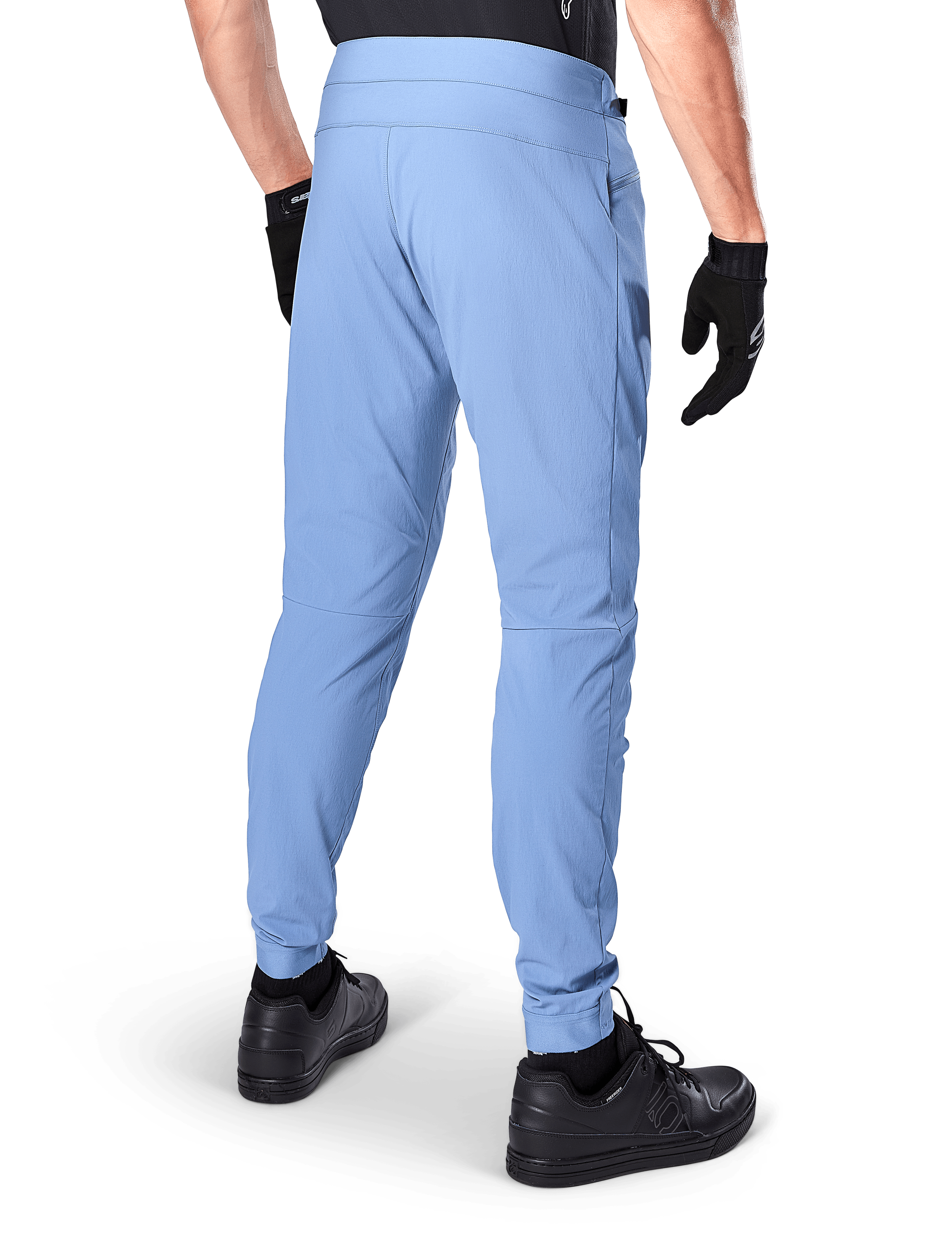 Alpinestars A-Dura Pants, mountainbikebroek, Infinity Blue, achteraanzicht met regular fit en elastische manchetten, gedragen met zwarte handschoenen en zwarte schoenen, duurzame fietskleding met 2-way stretch
