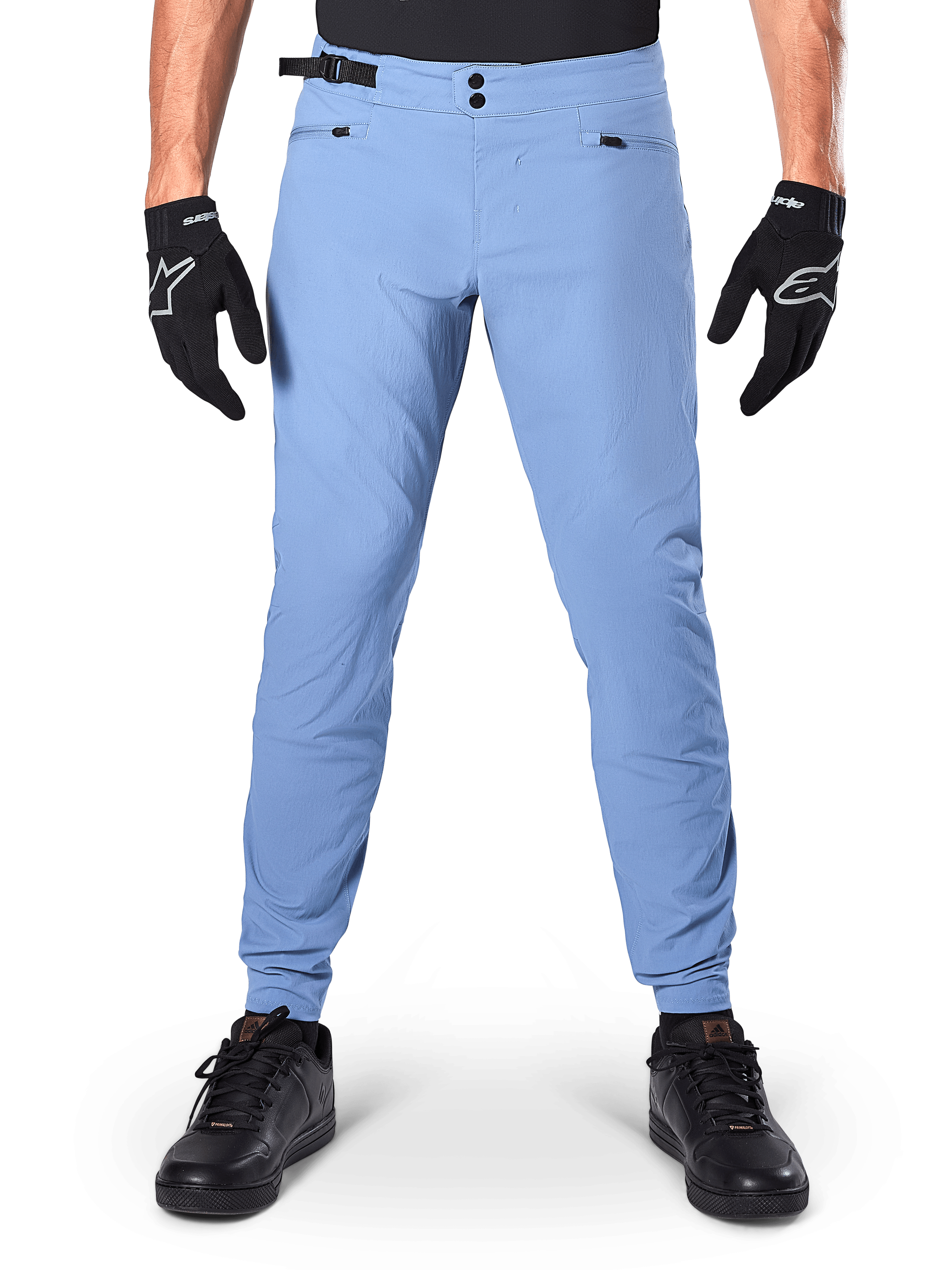 Alpinestars A-Dura Pants, MTB broek, Infinity Blue, lichtblauwe mountainbikebroek met dubbele drukknoopsluiting en zakken met ritssluiting, gedragen met zwarte handschoenen en zwarte schoenen, normale pasvorm met elastische manchetten