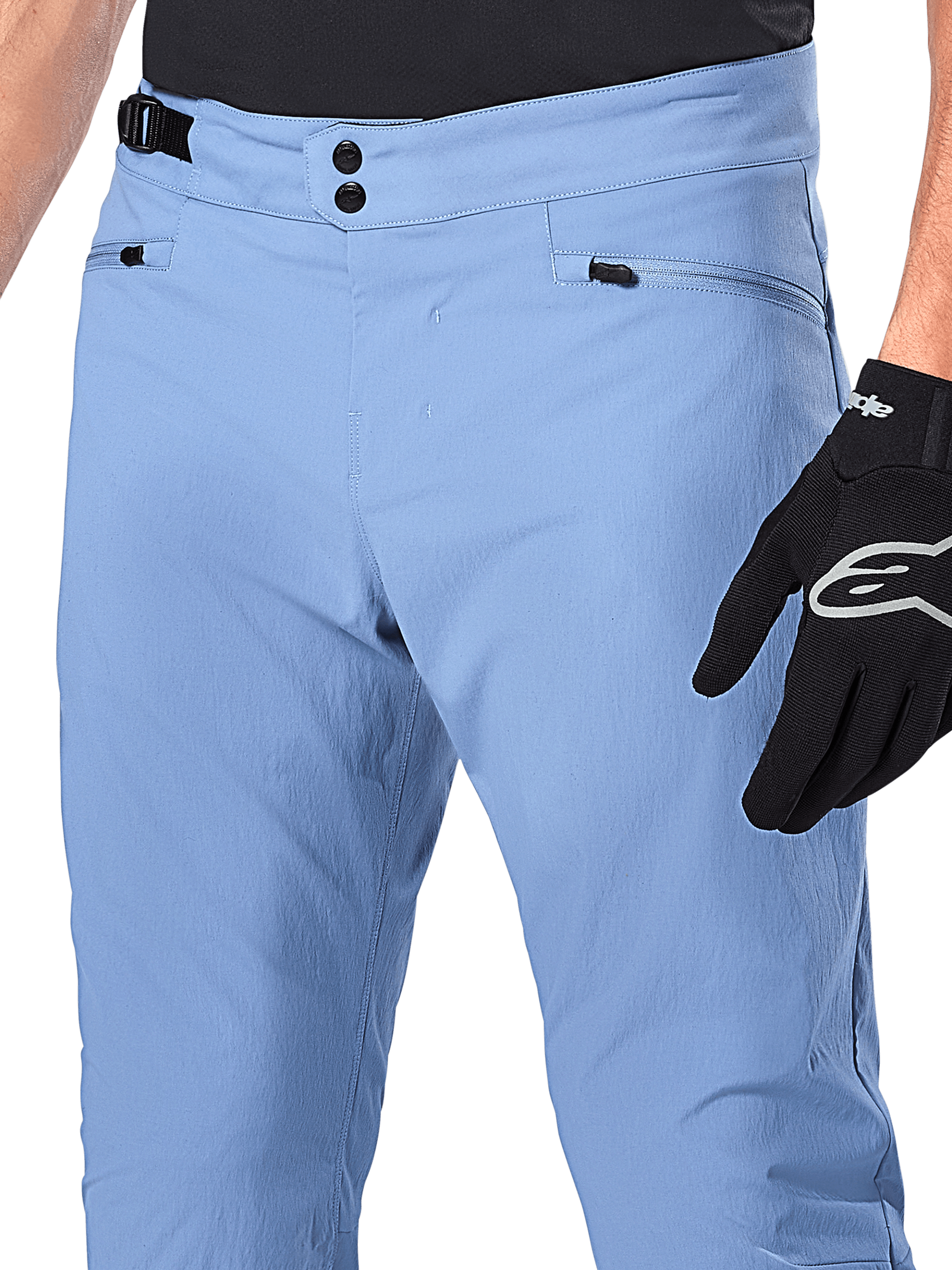 Alpinestars A-Dura Pants, MTB-fietsbroek, Infinity Blue, close-up van de taille met dubbele drukknoopsluiting en verstelbare tailleband aan de zijkant, zakken met rits, gedragen met zwarte Alpinestars handschoenen