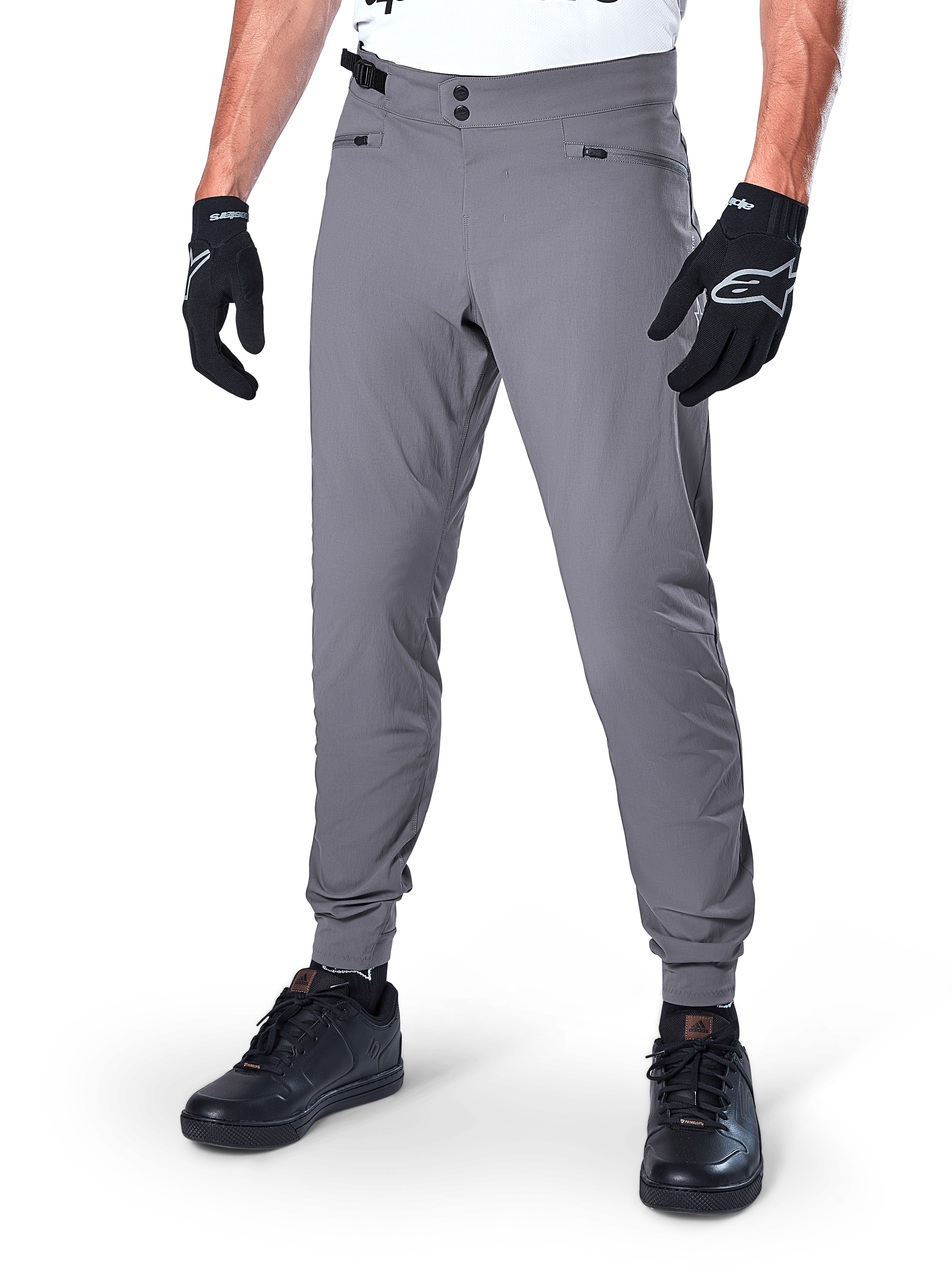 Alpinestars A-Dura Pants, Dark Gray MTB Pants, featuring double snap waist closure and zippered pockets, elasticated cuffs, worn with black cycling gloves and black sneakers