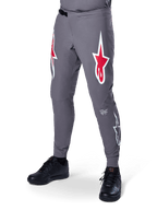 Pantalon Alpinestars A-Supra Race, pantalon de VTT gris foncé, avec grands logos étoile rouges et blancs sur les cuisses, ventilation perforée au laser et fermeture à rochet à la taille, coupe performance pour le downhill et l'enduro