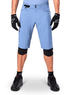 Short Alpinestars A-Dura, short de VTT bleu Infinity Blue, porté avec des gants noirs et des genouillères, doté d'une double fermeture à pression et d'un ajusteur de taille latéral, équipement de cyclisme haute performance pour le VTT