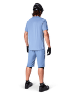 Vue arrière d'un vététiste portant le short Alpinestars A-Dura en Infinity Blue, maillot à manches courtes assorti, casque noir, gants noirs et chaussures noires, équipement de performance coordonné pour le trail VTT