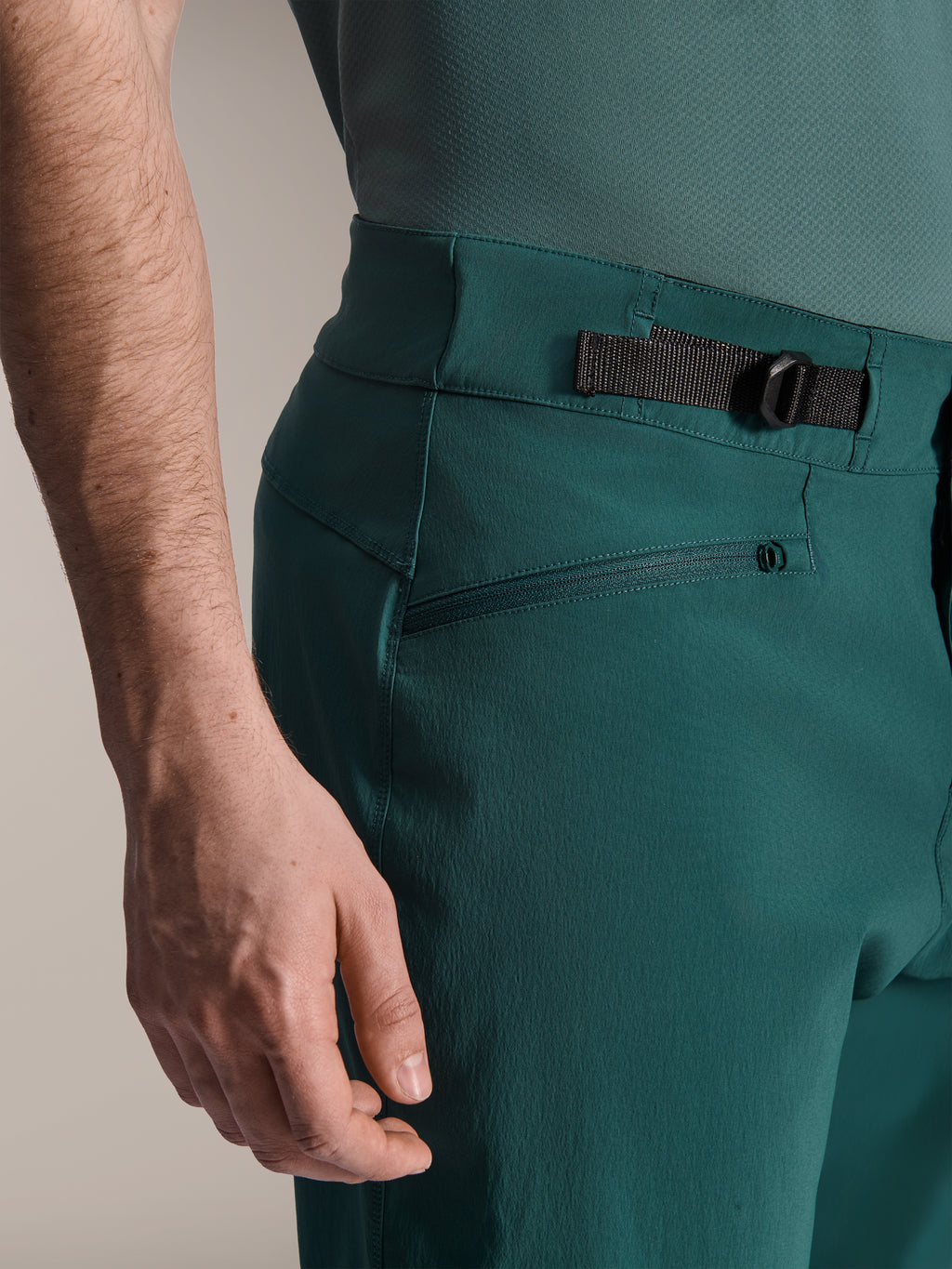 Alpinestars A-Dura Shorts, Dark Pine groen, close-up van de verstelbare zijdelingse tailleband en ritszak, duurzame kleding voor mountainbiken.