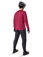 Alpinestars A-Dura Thermal Jersey, maillot de cyclisme à manches longues bordeaux, vue de dos, porté avec un pantalon de VTT noir et un casque gris, doté d'un pan arrière allongé pour une couverture arrière accrue, équipement de VTT pour temps froid